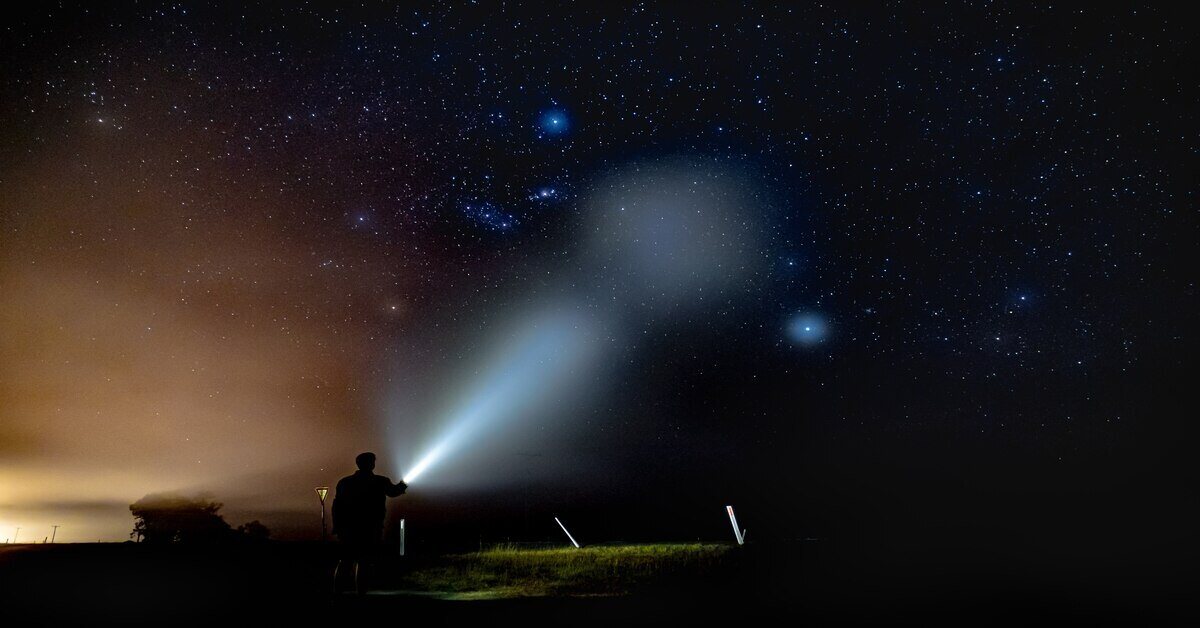 man with flashlight hiking at night