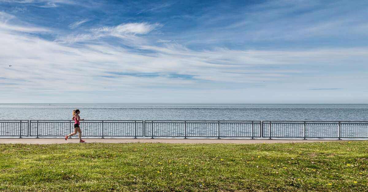 a woman running next to a beach