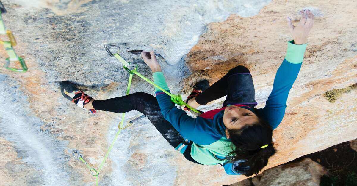 woman climbing a rock