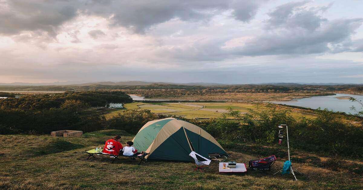 two campers outside a tent