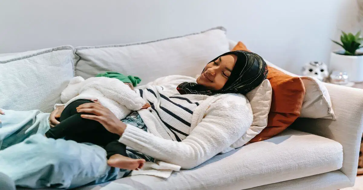 mum lying on the couch breastfeeding her baby