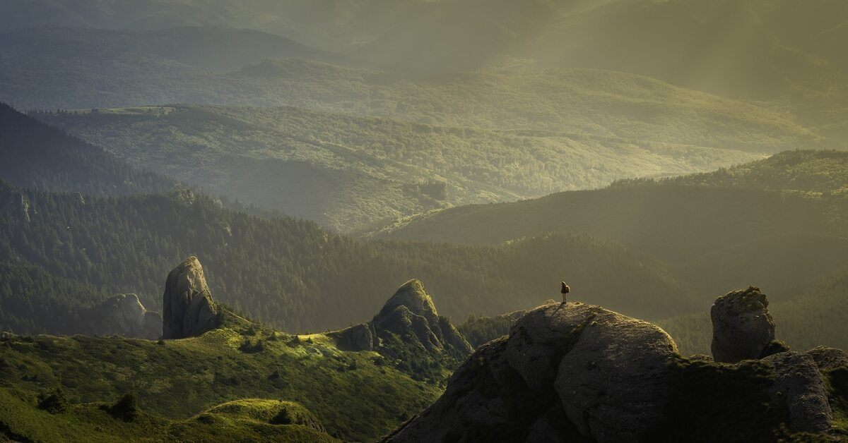 person standing on a boulder