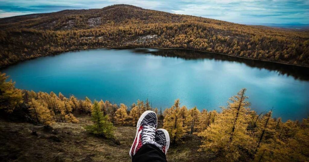 hiker's feet near lake