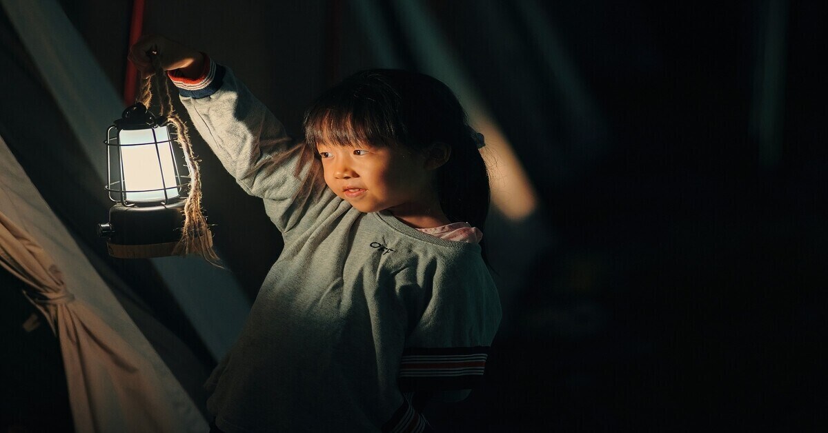 Girl holding lantern in tent