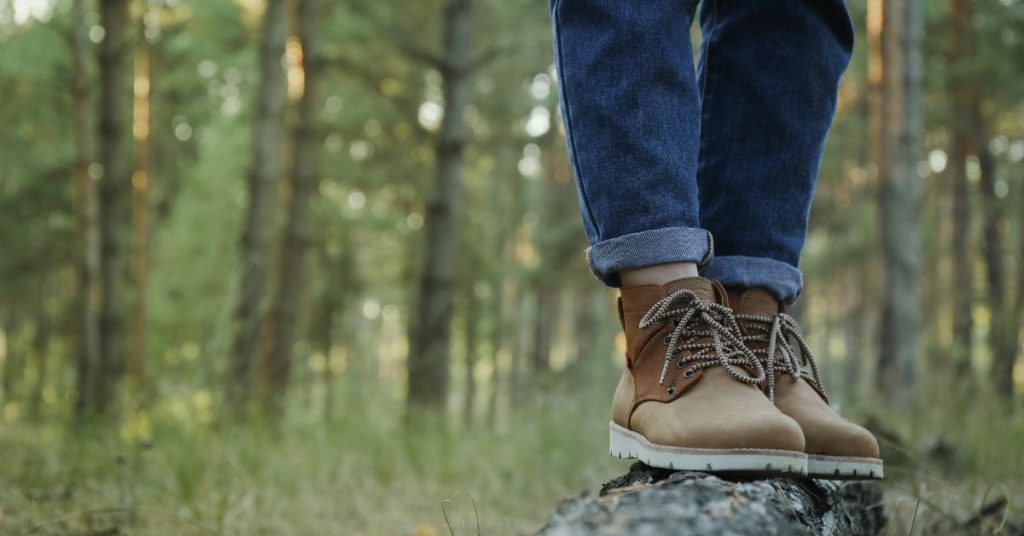 lower part of hiker's legs showing a pair of jeans and boots