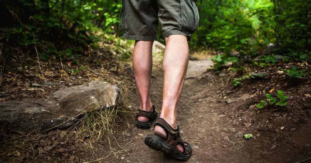 hiker wearing sandals walking on trail